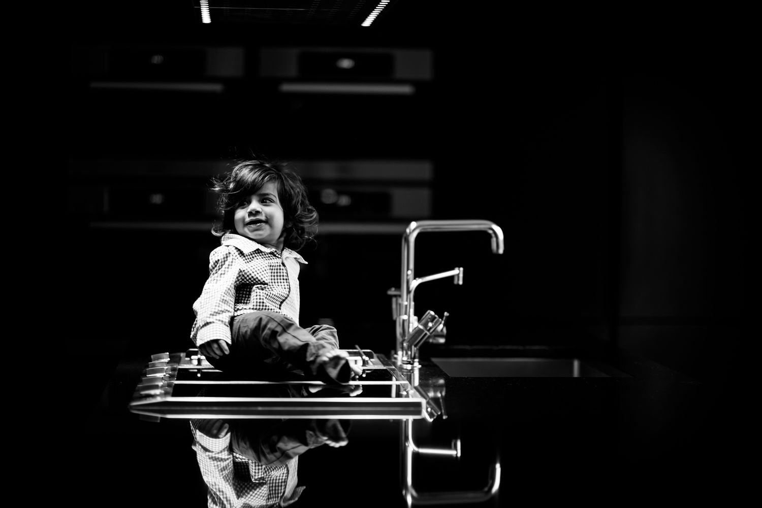 A pianist performs passionately at a grand piano during a concert in a dark theater setting.