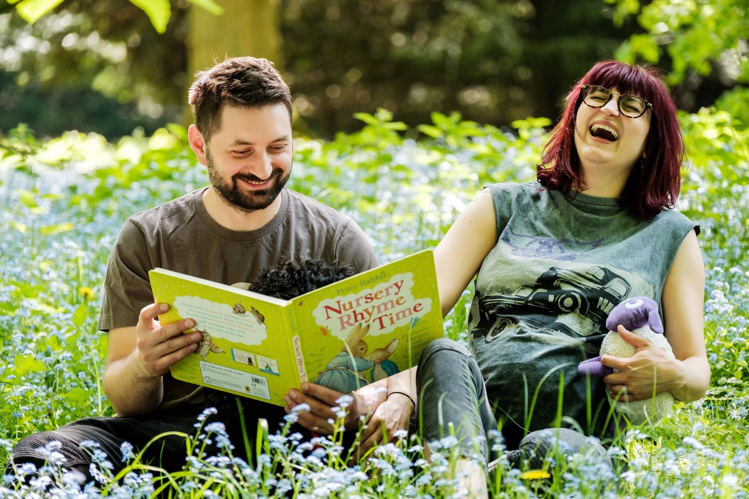 Two people reading books together while relaxing in a lush green garden setting.