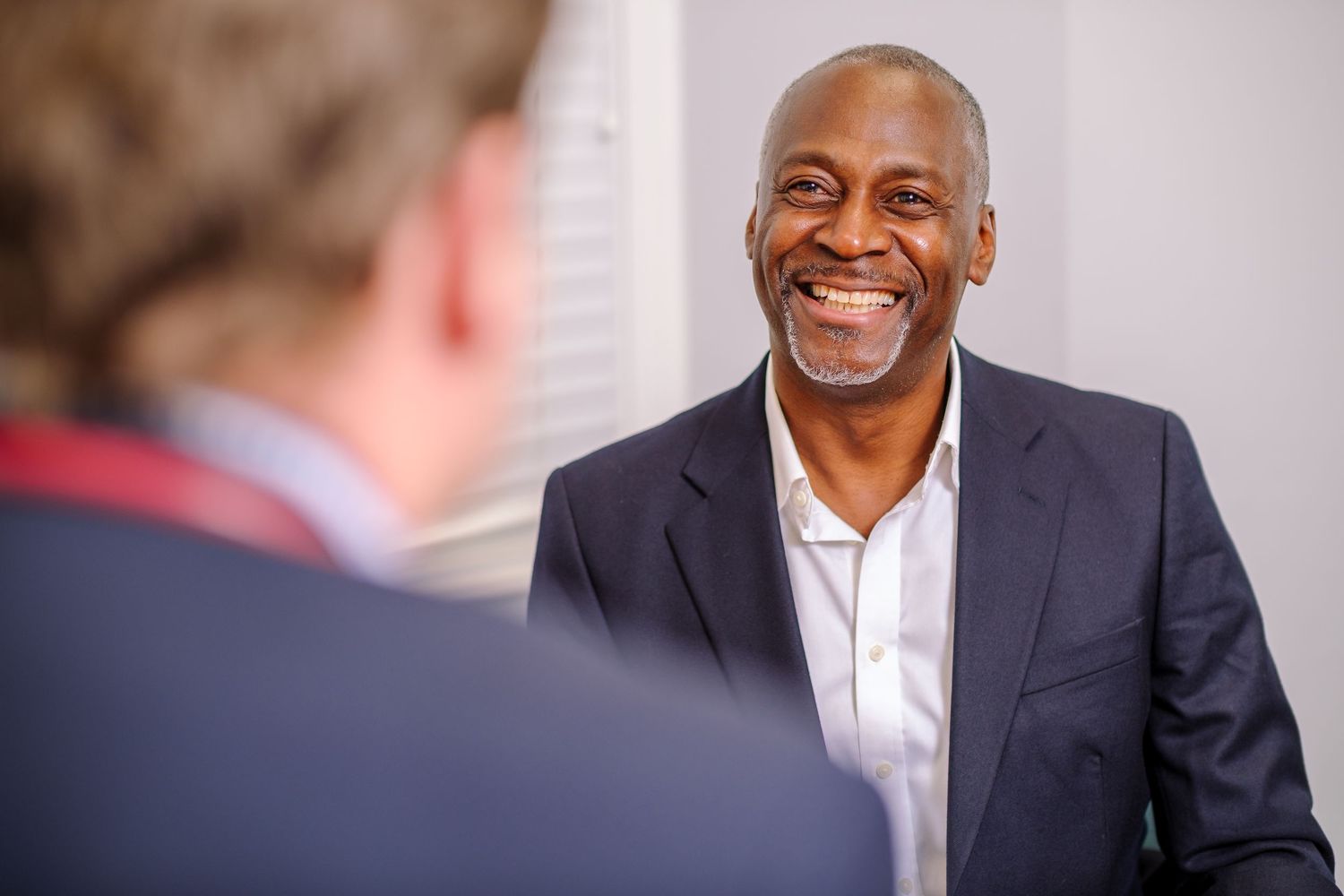 Professional business portraits showing warm expressions against light studio background.