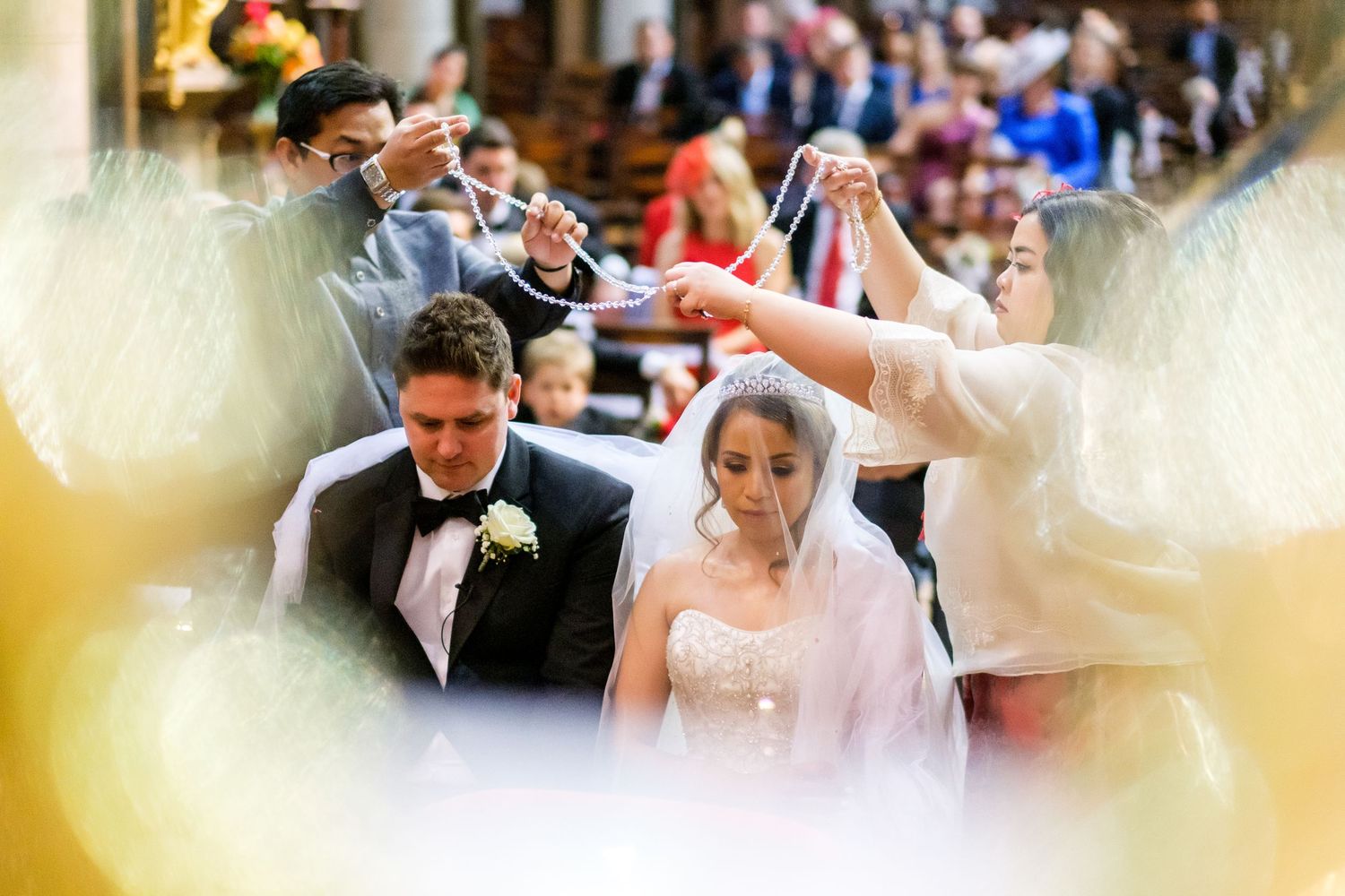 Soft focus wedding ceremony moments captured through decorative elements in warm lighting.
