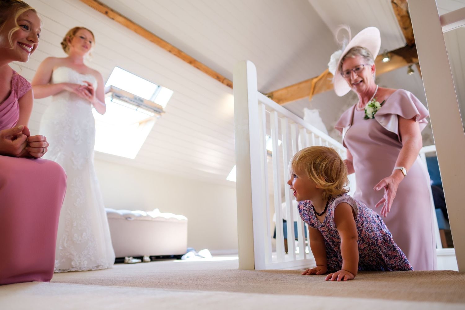 People in a bright attic space prepare for a special occasion with natural light streaming through skylights.