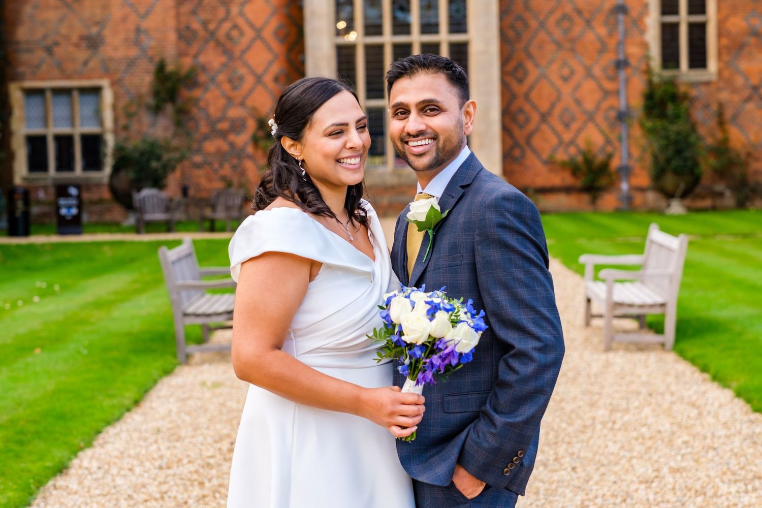 Couple celebrating their wedding day in front of a beautiful historic brick manor house.