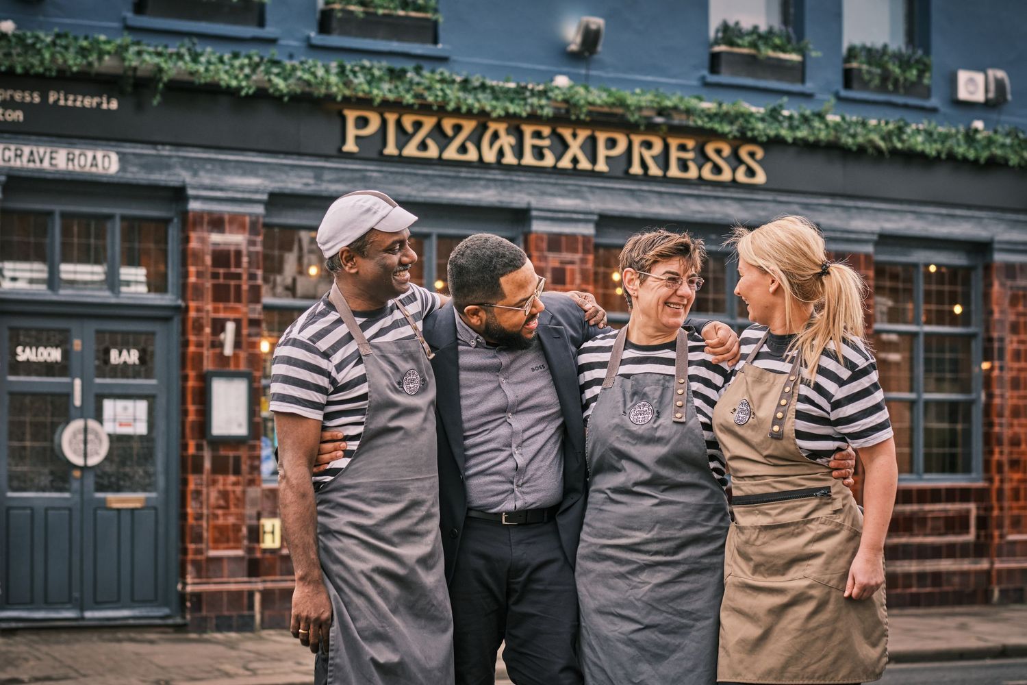 Pizza Express restaurant exterior with staff and signage visible.