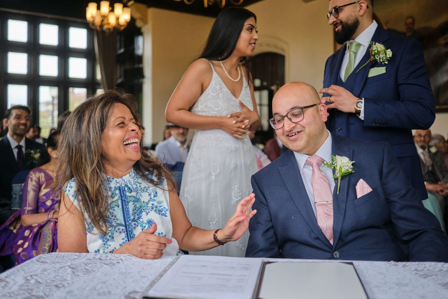 Wedding celebration in an elegant venue with chandelier and guests.