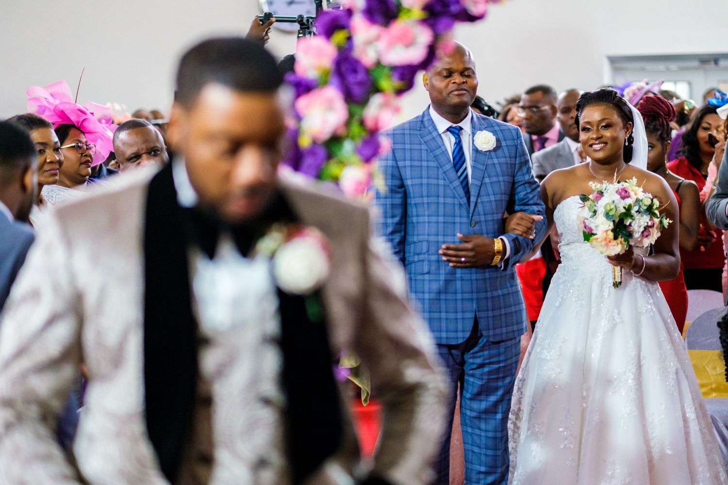 Wedding ceremony in progress with formal attire and floral decorations.