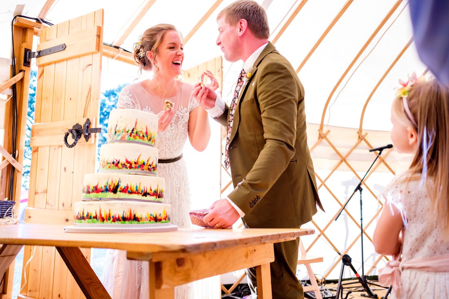 Couple shares a joyful moment during their wedding reception inside a rustic yurt.