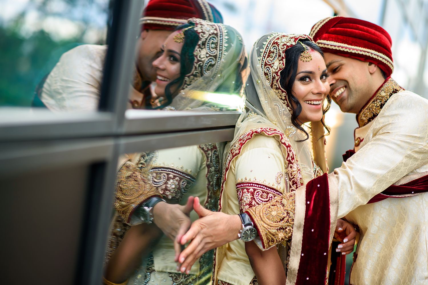 Couple in traditional Indian wedding attire sharing an intimate moment outdoors.