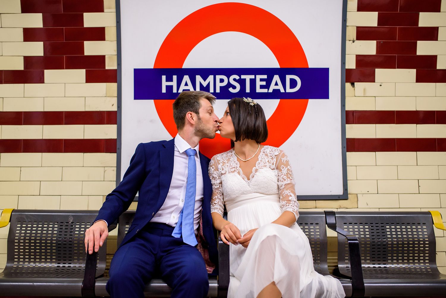 London Underground station platform with iconic red circle logo and tile walls.