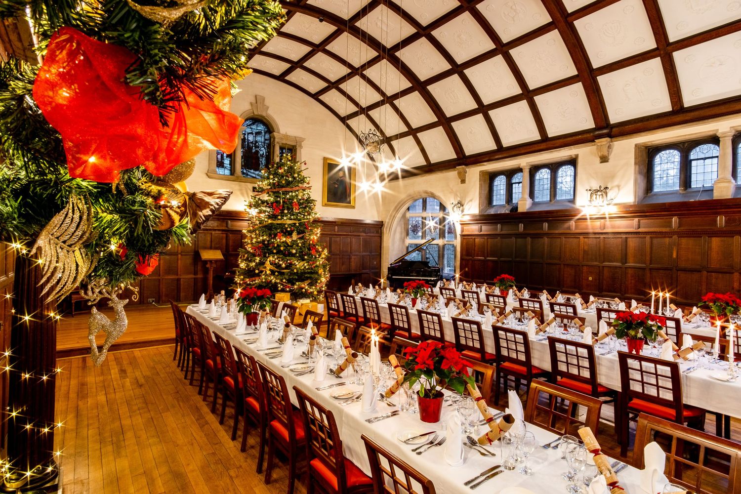 Elegant banquet hall decorated for Christmas with red and green holiday decor.