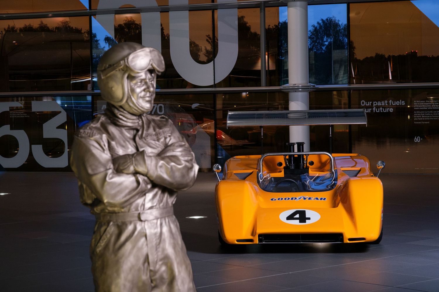 Vintage racing cars on display at an indoor museum or showroom.