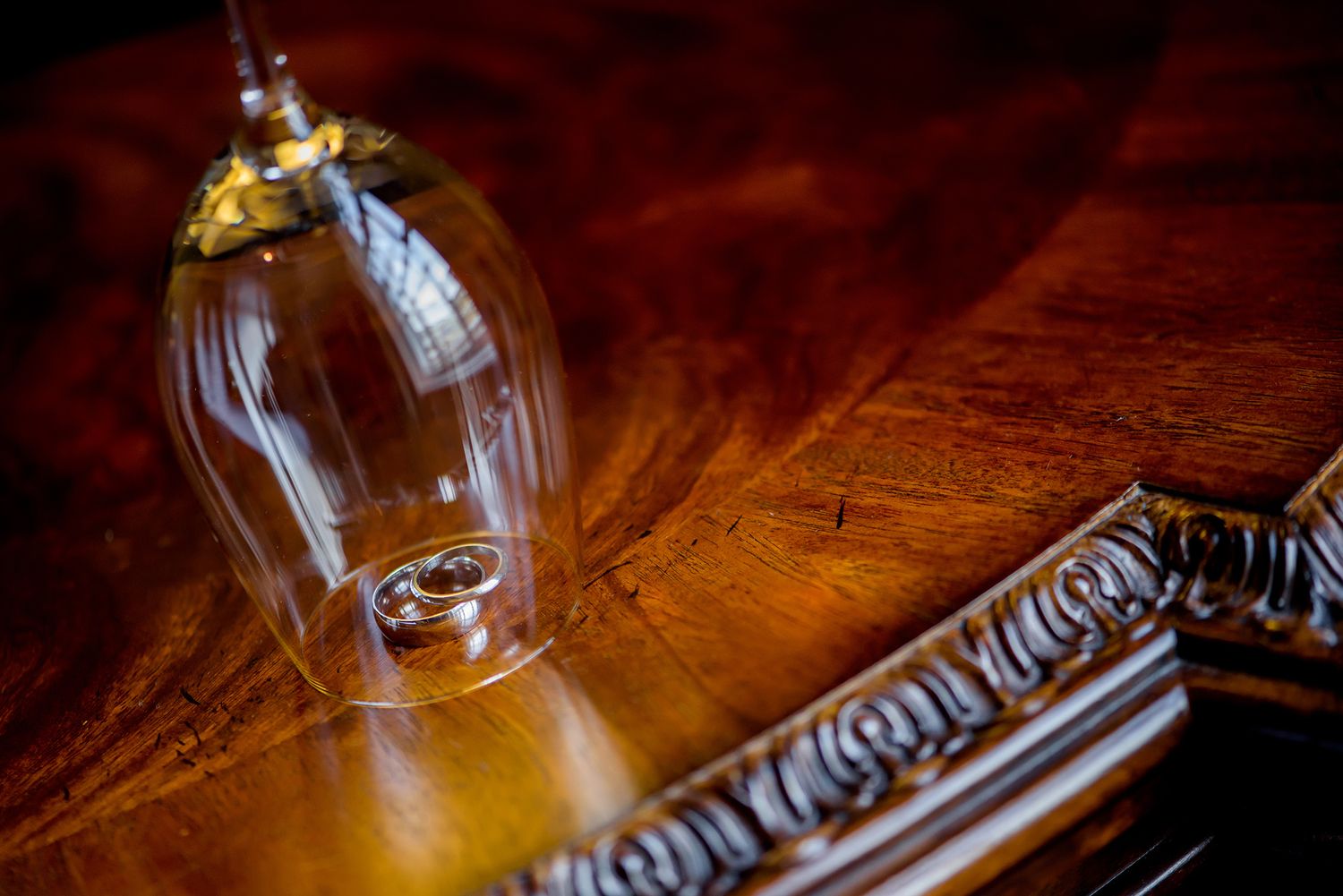 Elegant glass bottles on rustic wooden surface with warm ambient lighting.