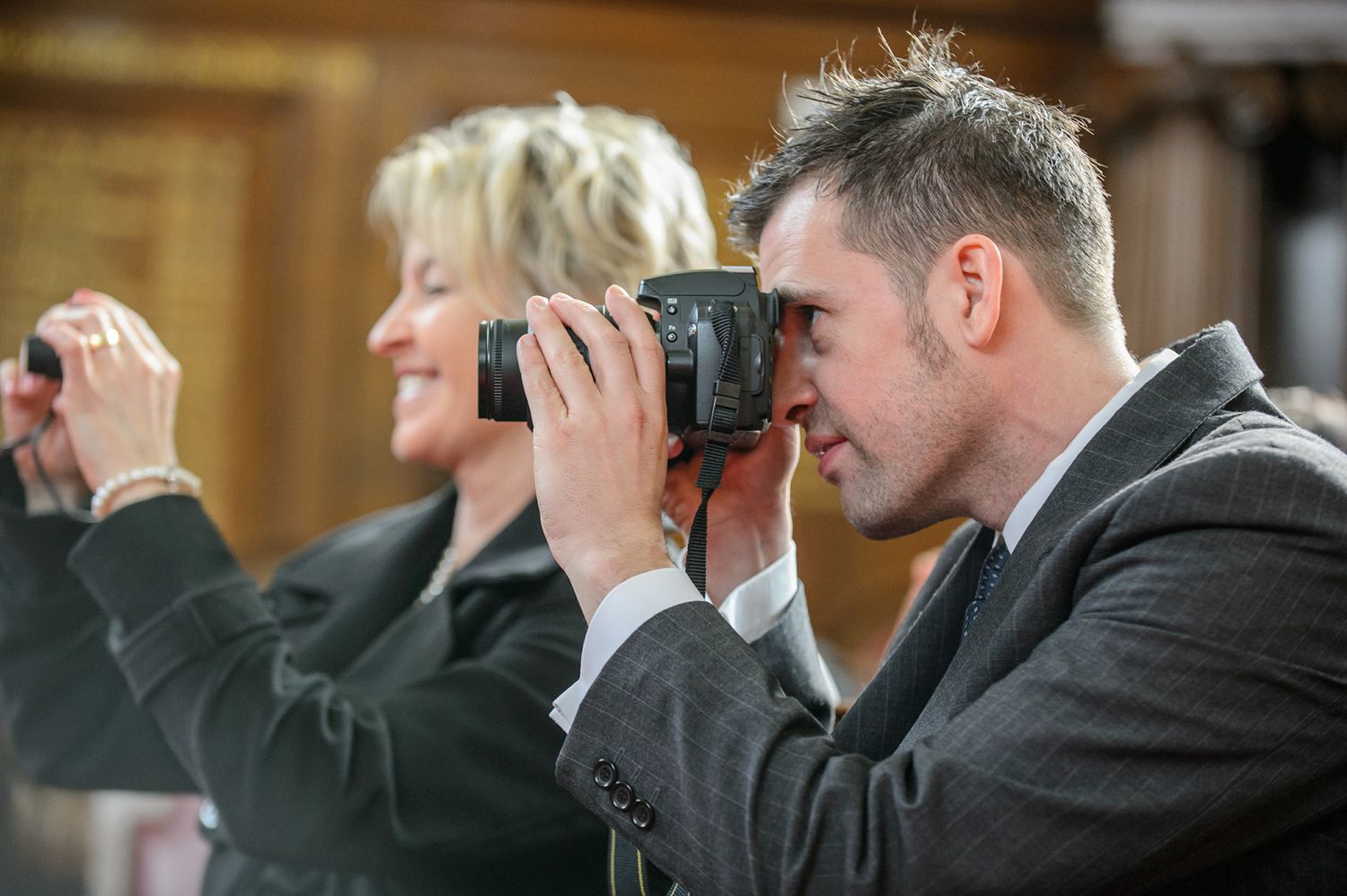 Wedding guests taking photos with cameras during the celebration.