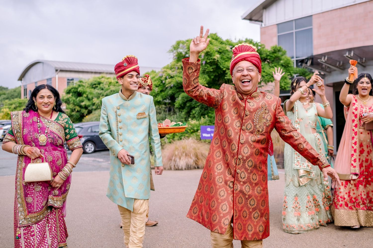 Wedding party members in traditional Indian attire posing together outdoors.