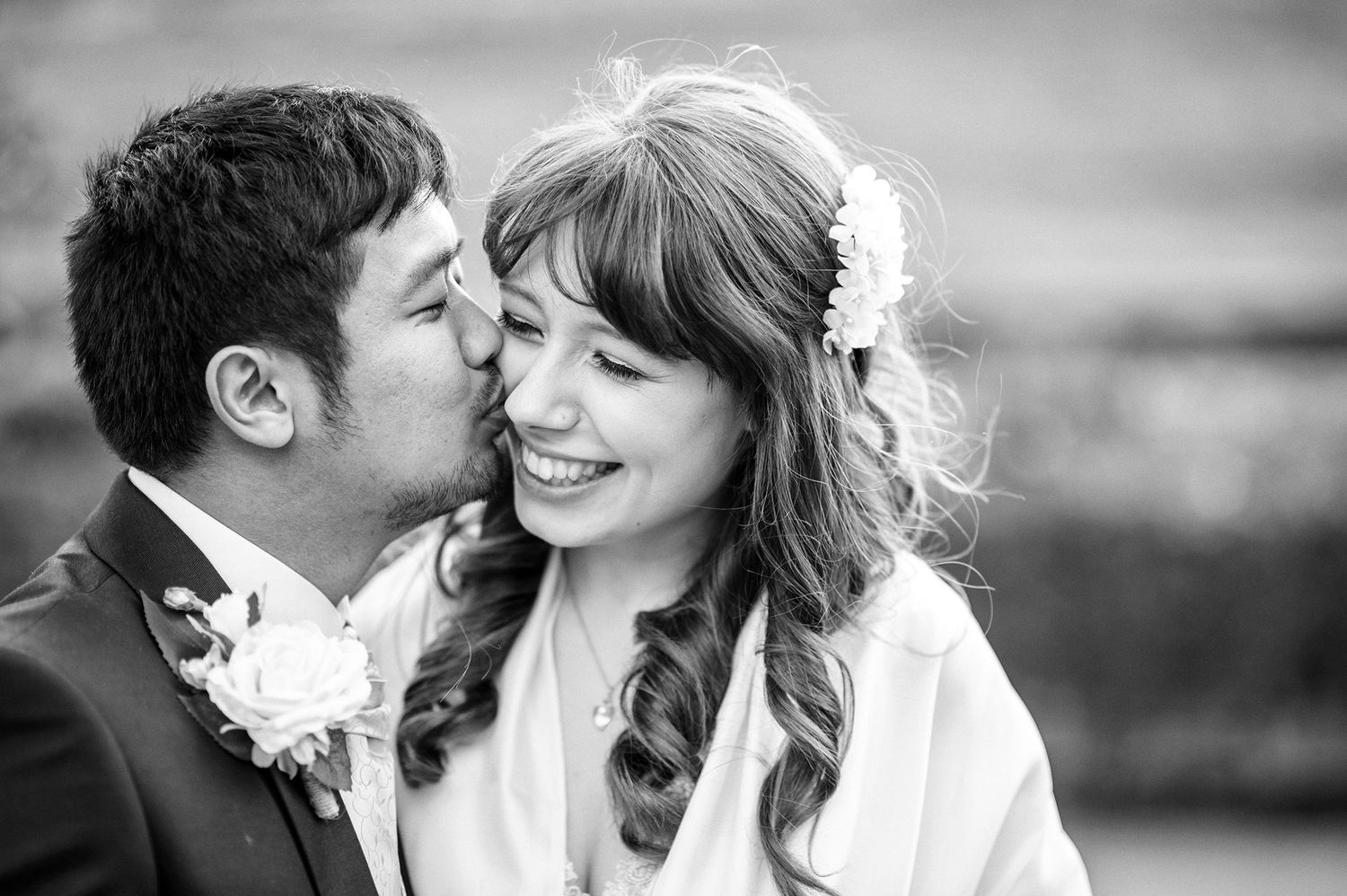 Intimate black and white wedding portrait showing tender moment between newlyweds.
