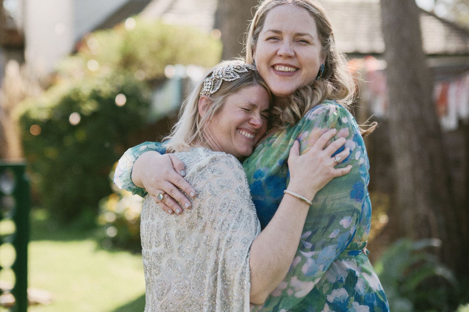 Emotional embrace shared during outdoor wedding celebration.