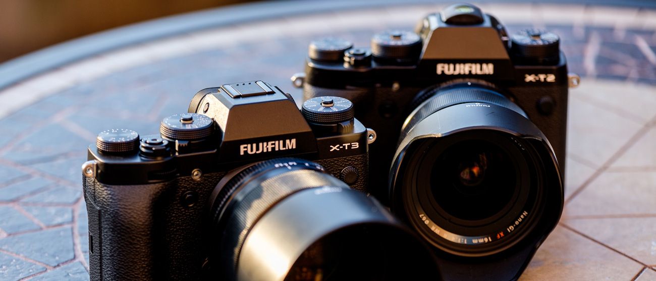 Line of Fujifilm digital cameras displayed on a light surface.
