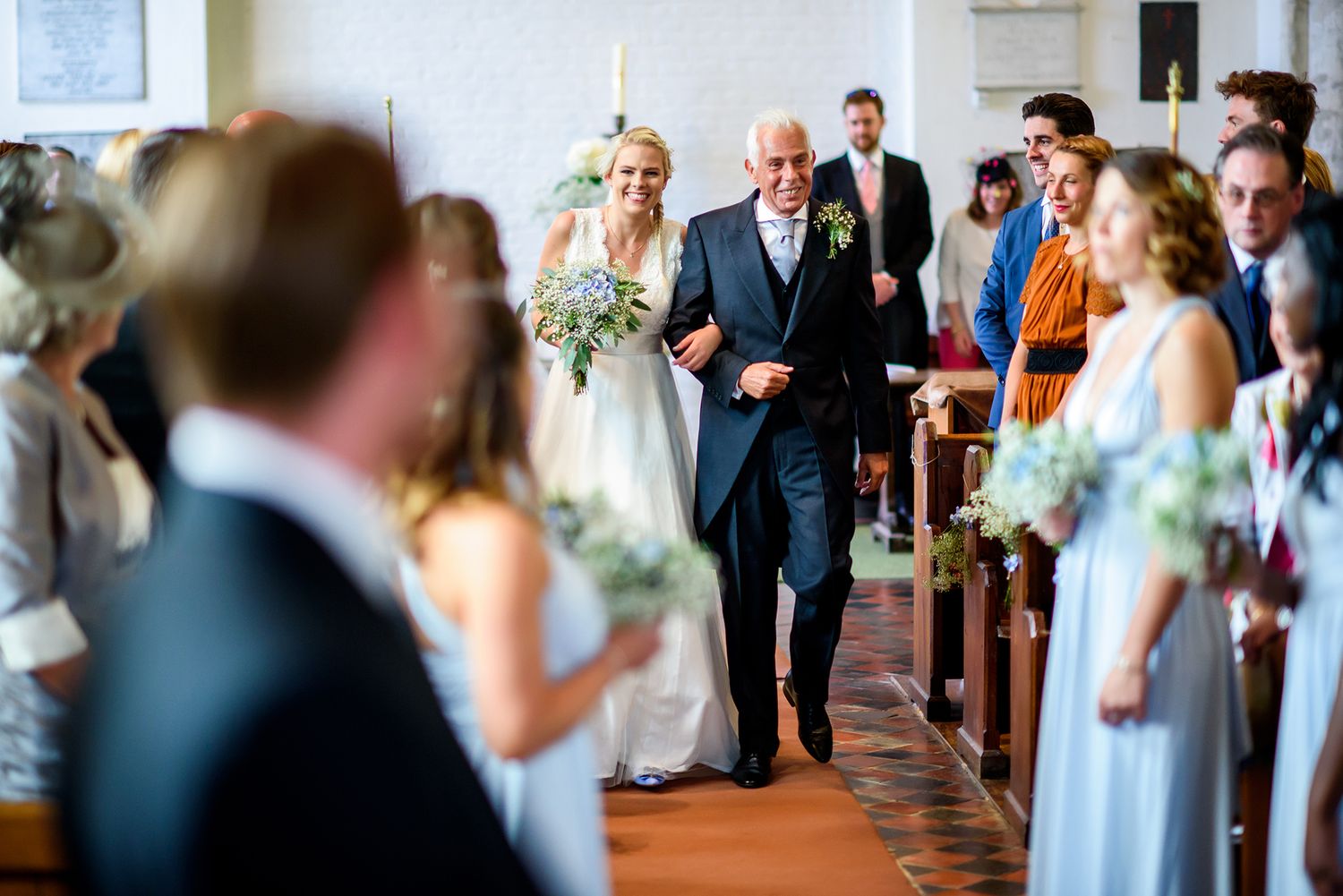 Traditional church wedding ceremony with guests seated in wooden pews.