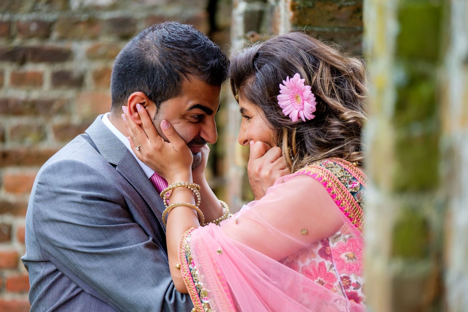 Intimate romantic moments captured in a garden setting with pink floral accents.
