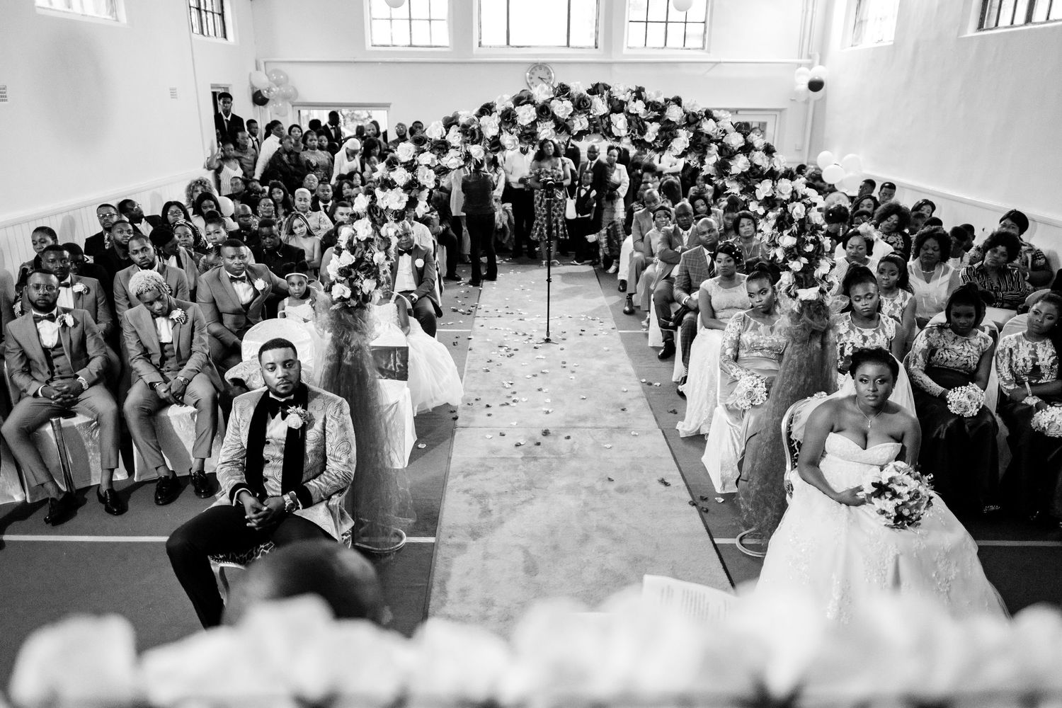 Large crowd gathered in formal attire inside bright church sanctuary.