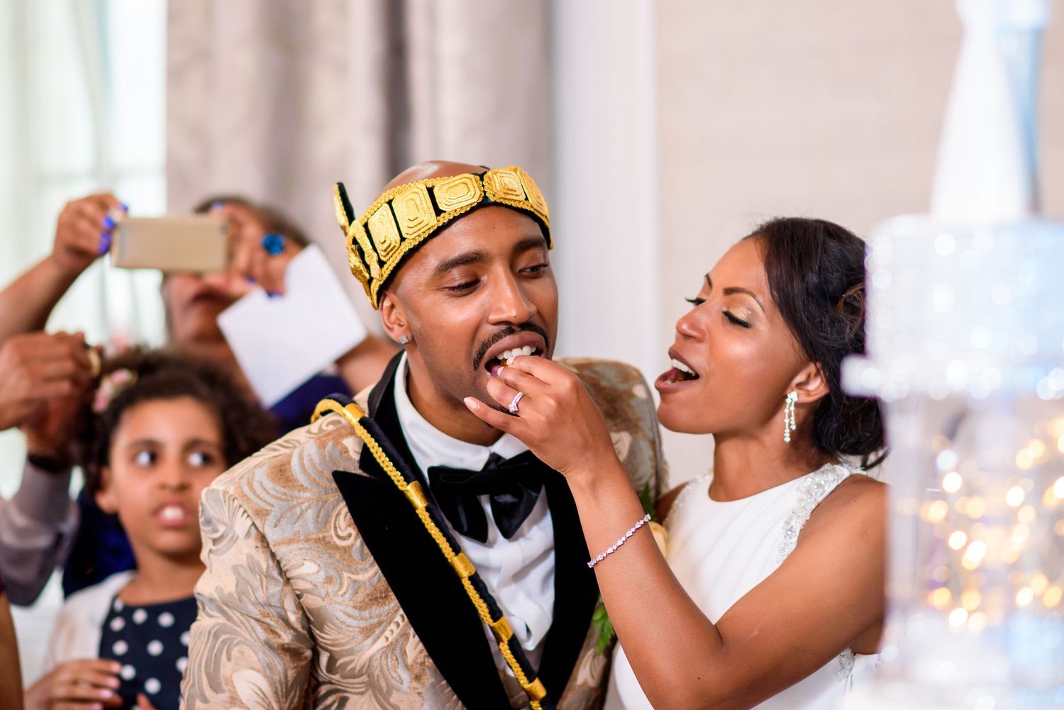 Wedding party celebrates with laughter and dancing during indoor reception.