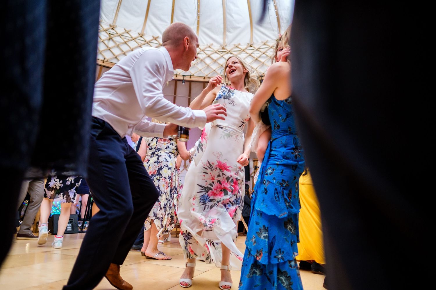 Guests dancing and celebrating at a lively indoor wedding reception.