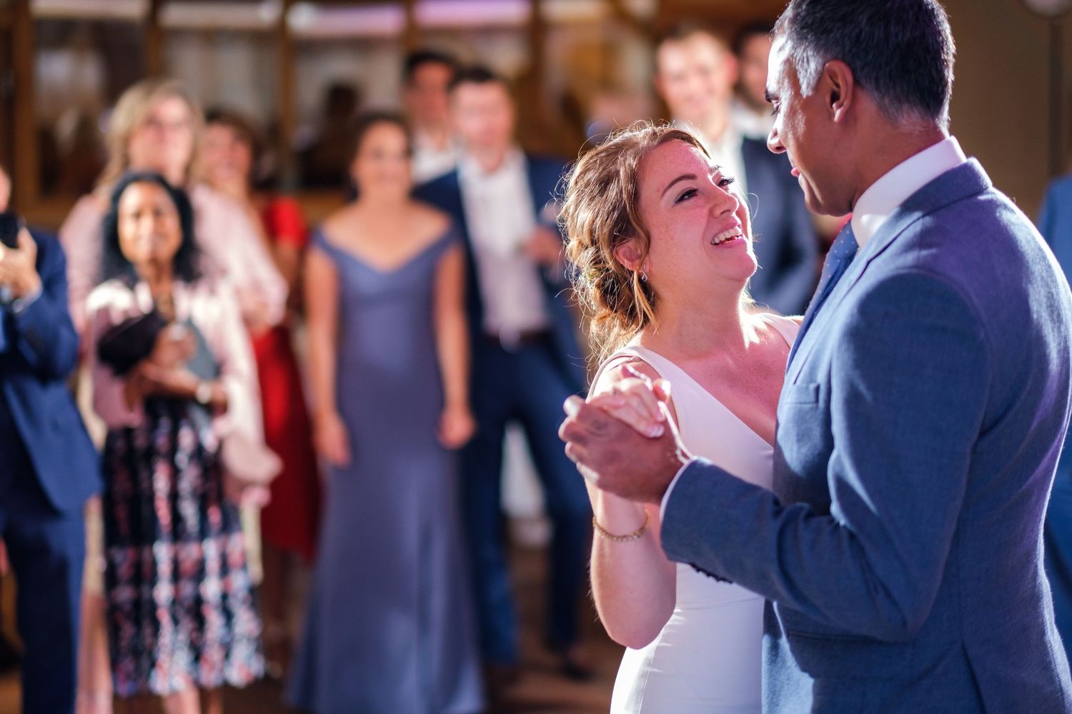 Couple sharing a romantic dance moment at an indoor wedding reception.