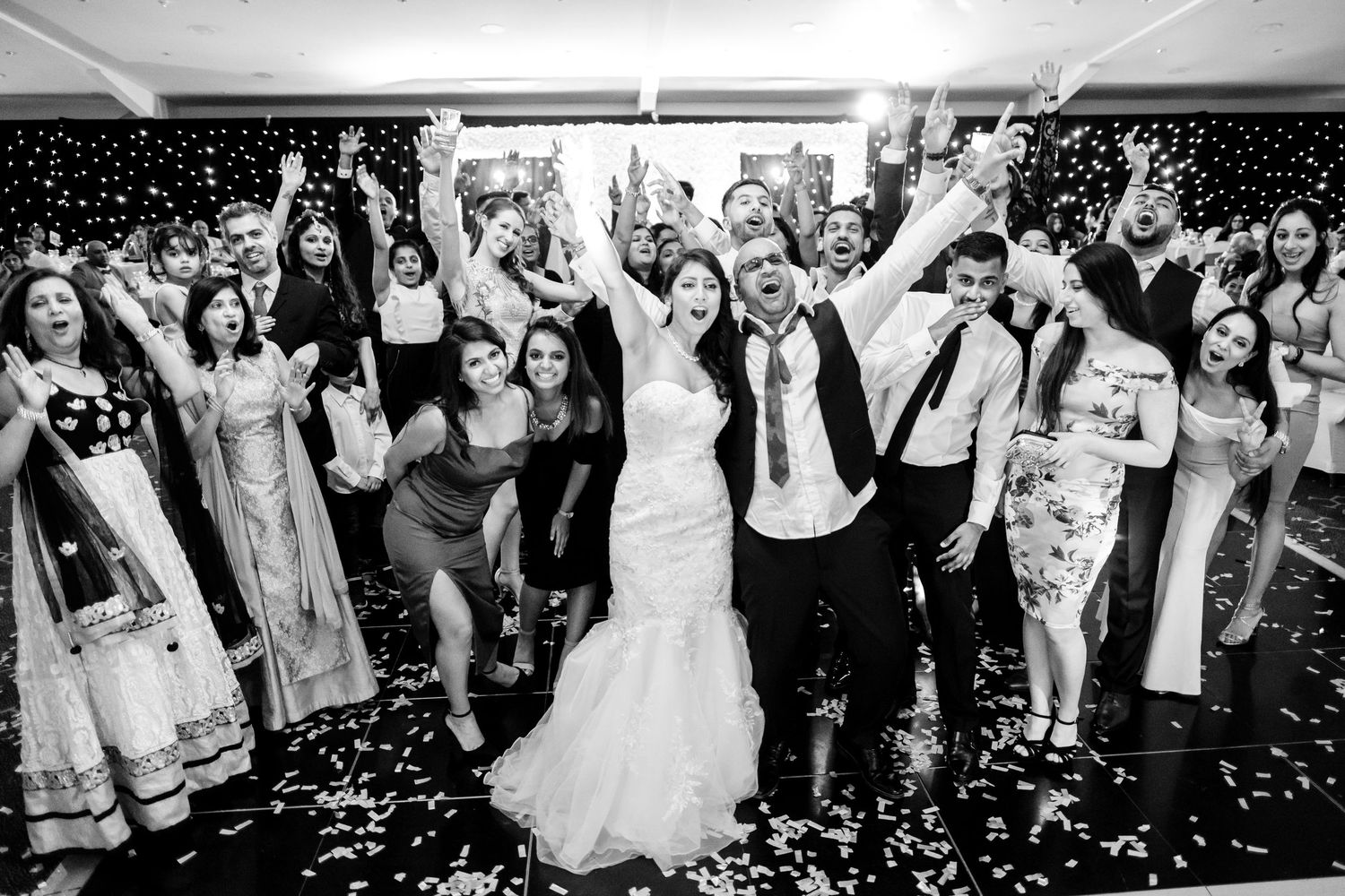 Black and white shots of wedding reception celebration with confetti and dancing guests.