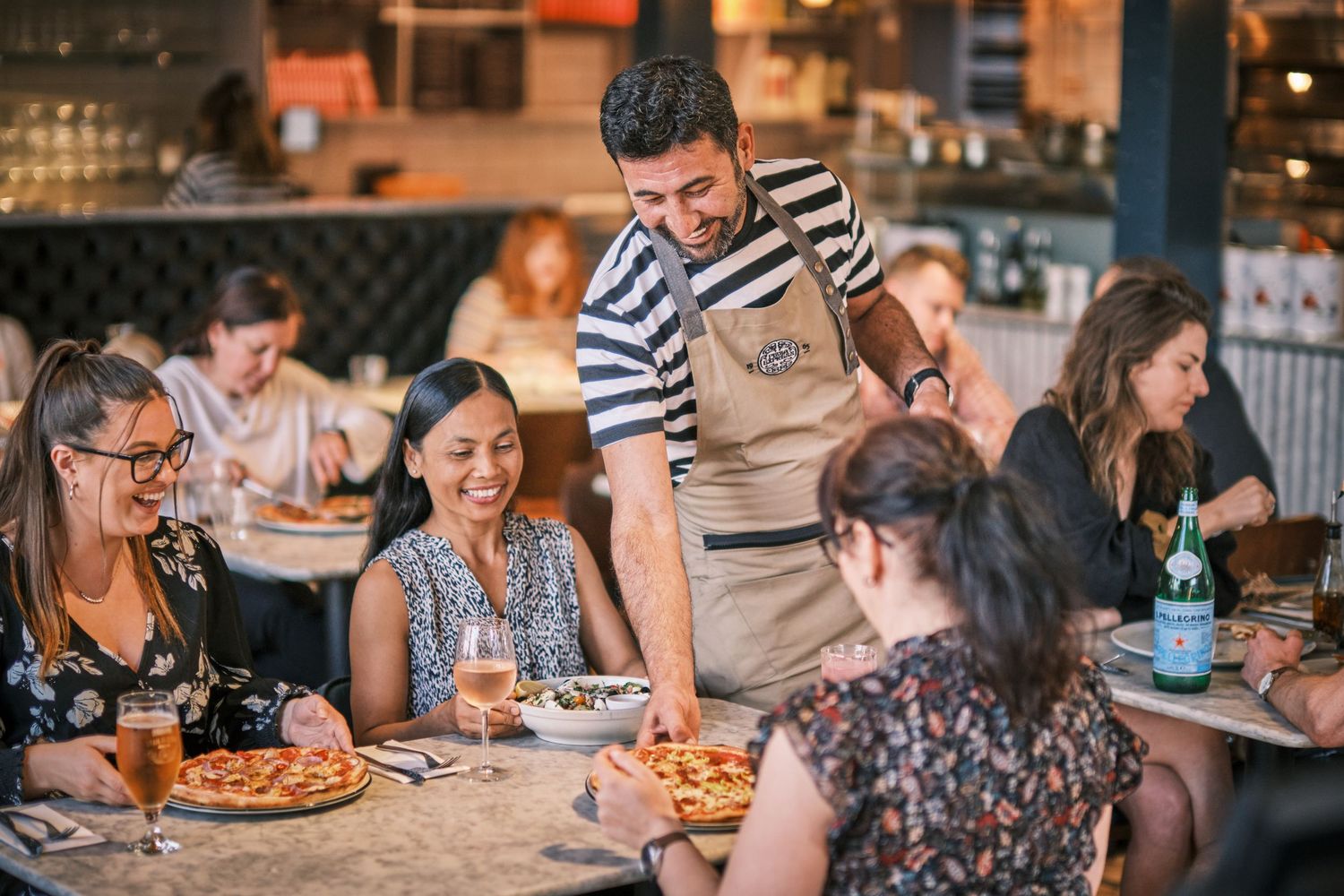 Casual dining atmosphere with groups enjoying meals at restaurant tables.