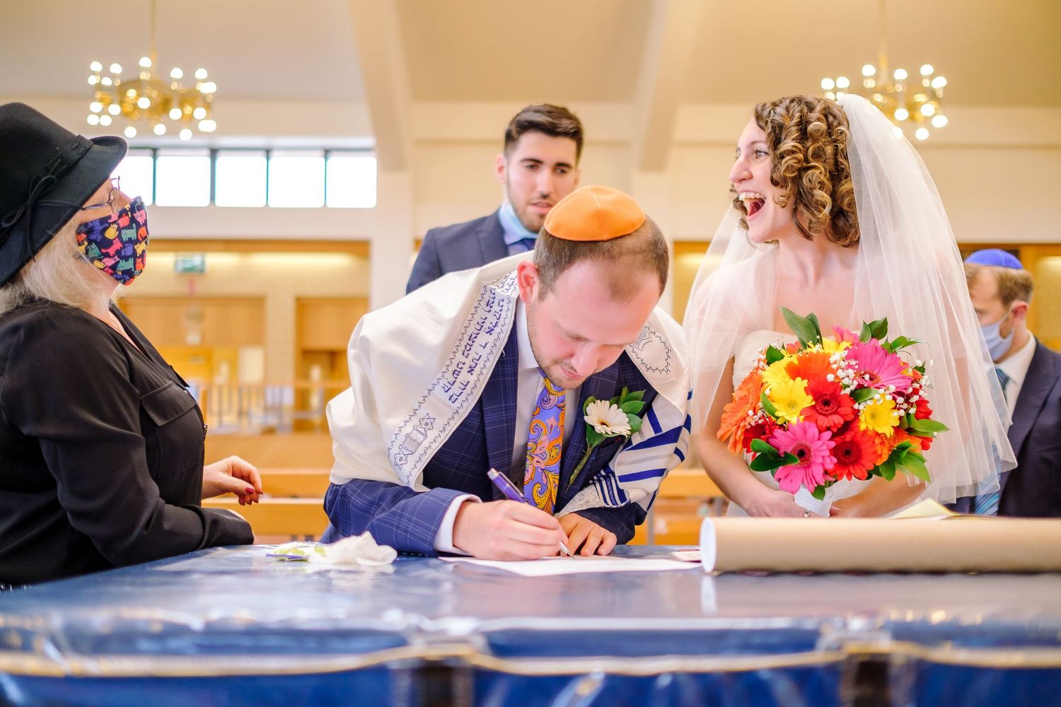 A series of candid moments from a wedding celebration showing guests signing a guestbook and decorative floral arrangements.
