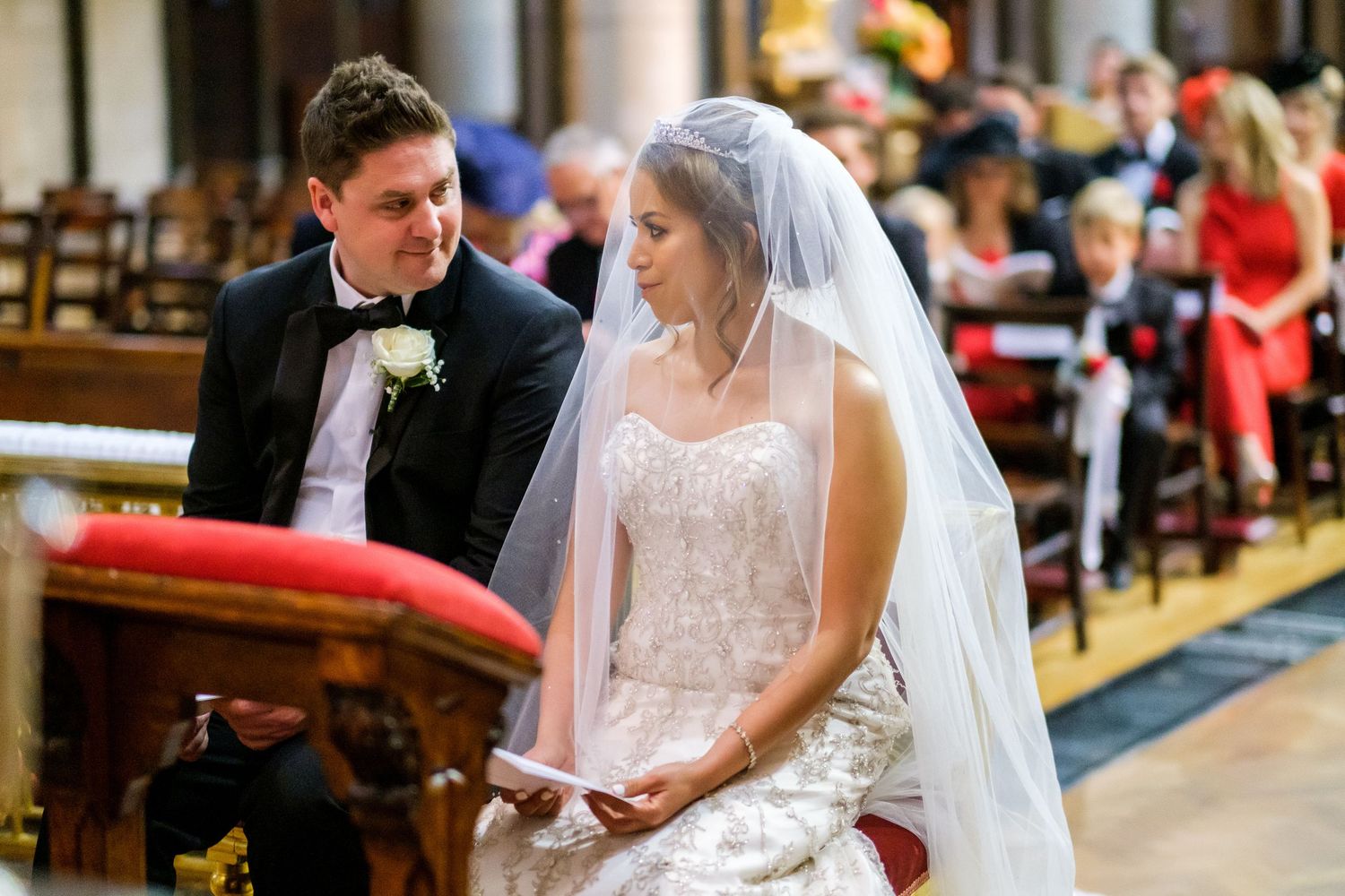 Traditional church wedding ceremony with bride in white dress and veil at the altar.
