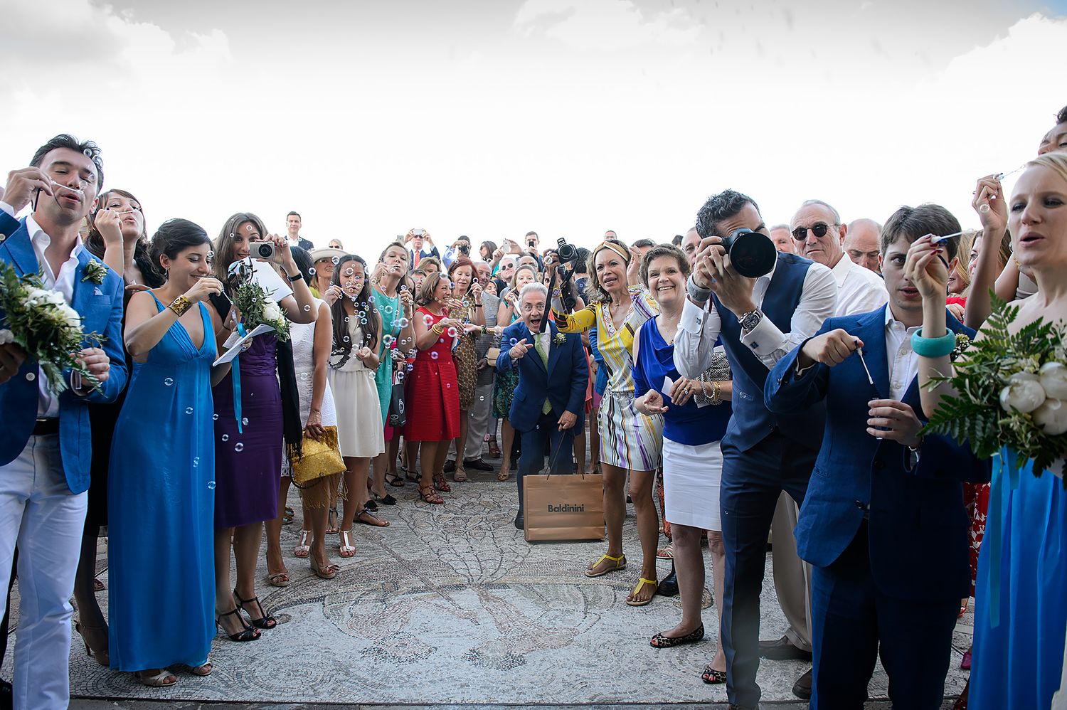 Wedding party and guests lined up outside for a celebratory moment.