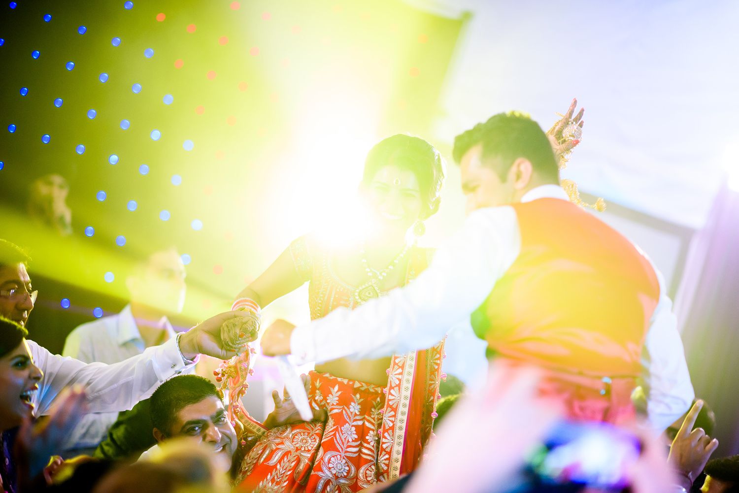 Yellow and purple stage lighting creates a dramatic atmosphere at a lively celebration event.