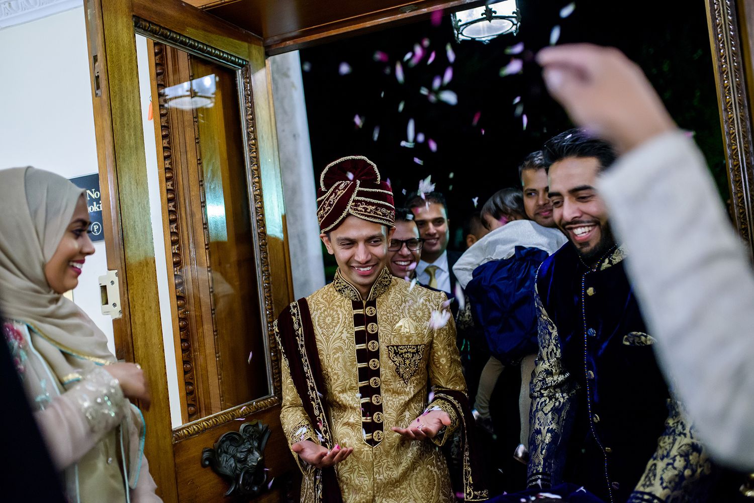 Guests gather joyfully in formal attire for a traditional wedding celebration at an elegant venue.