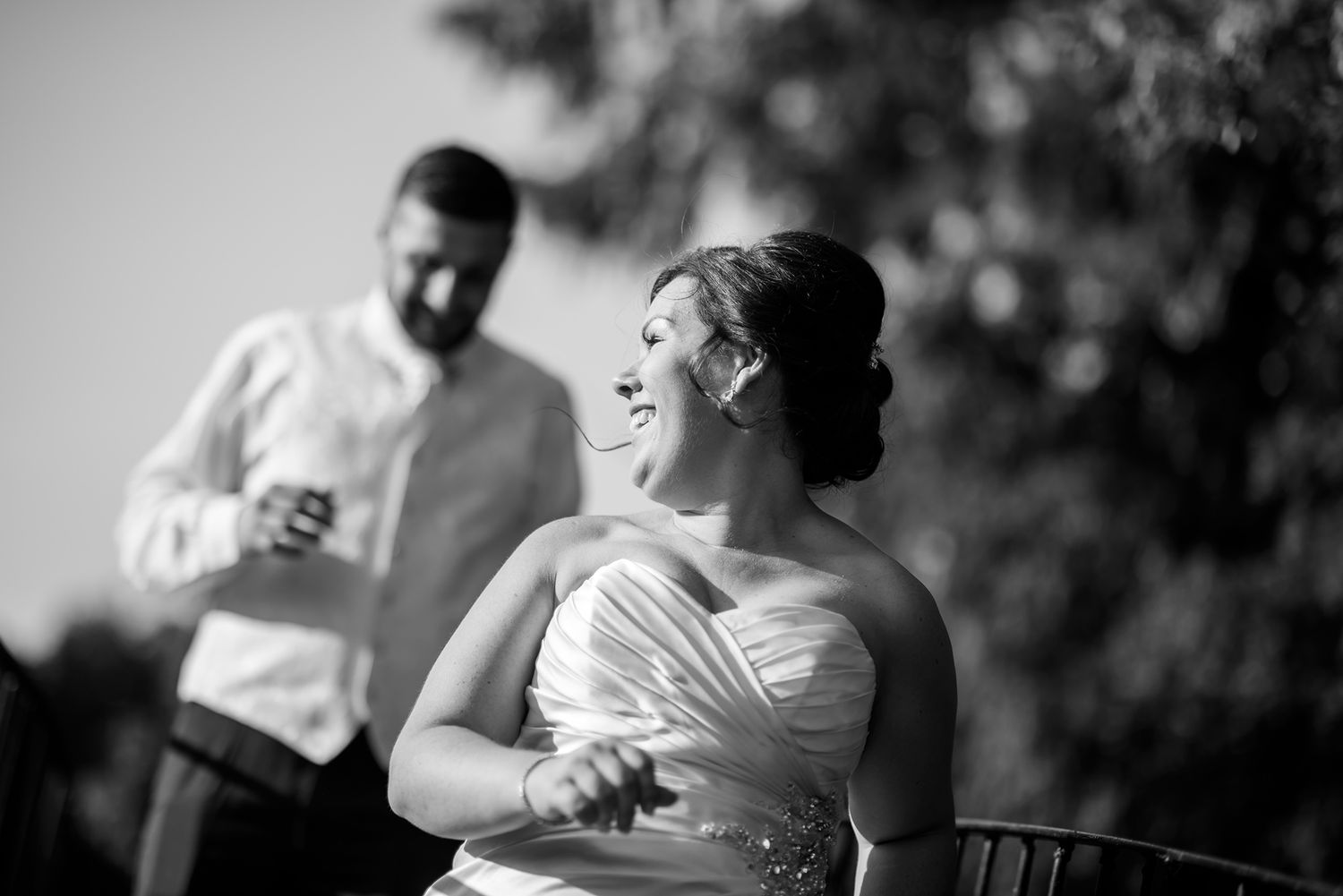Candid black and white moment captured during outdoor wedding celebration.