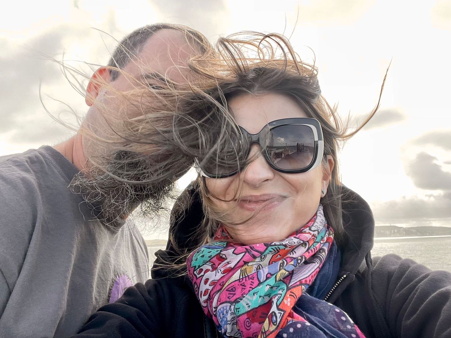 Collection of windswept selfies with bright backlight and colorful accessories.