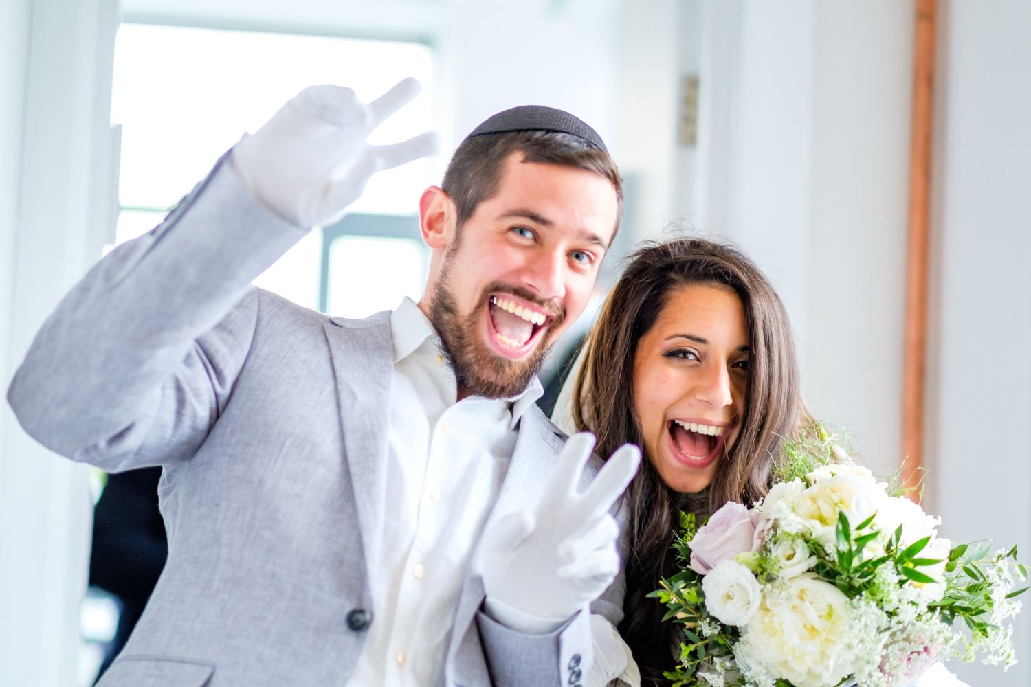 Wedding party members laughing and celebrating together in a candid moment.