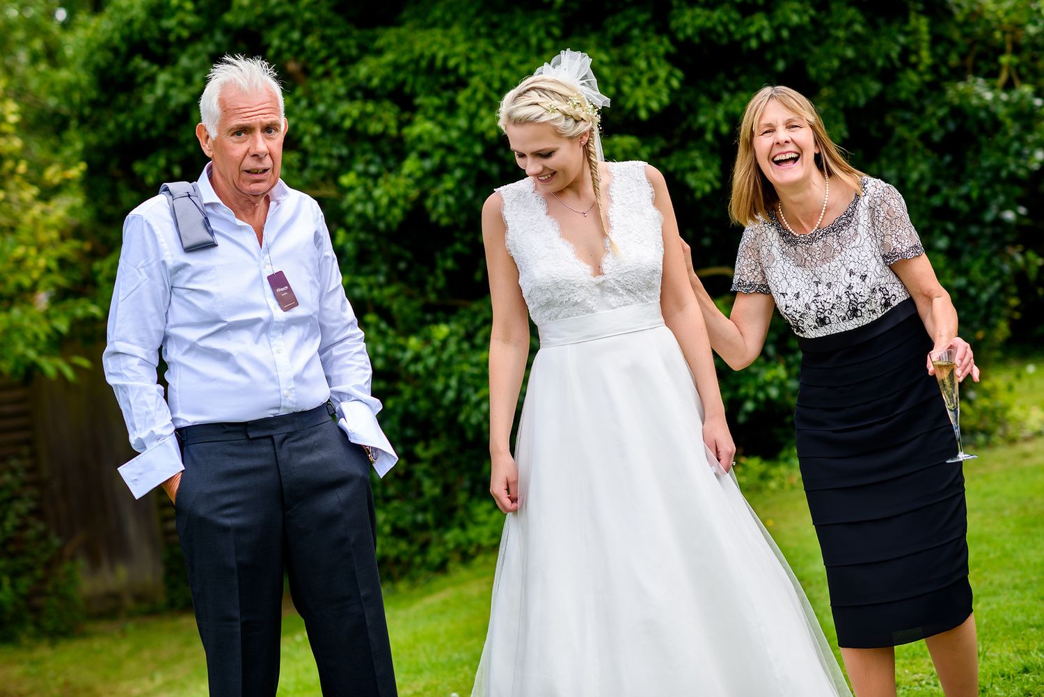 Wedding party enjoying candid moments on a lush green lawn during celebrations.