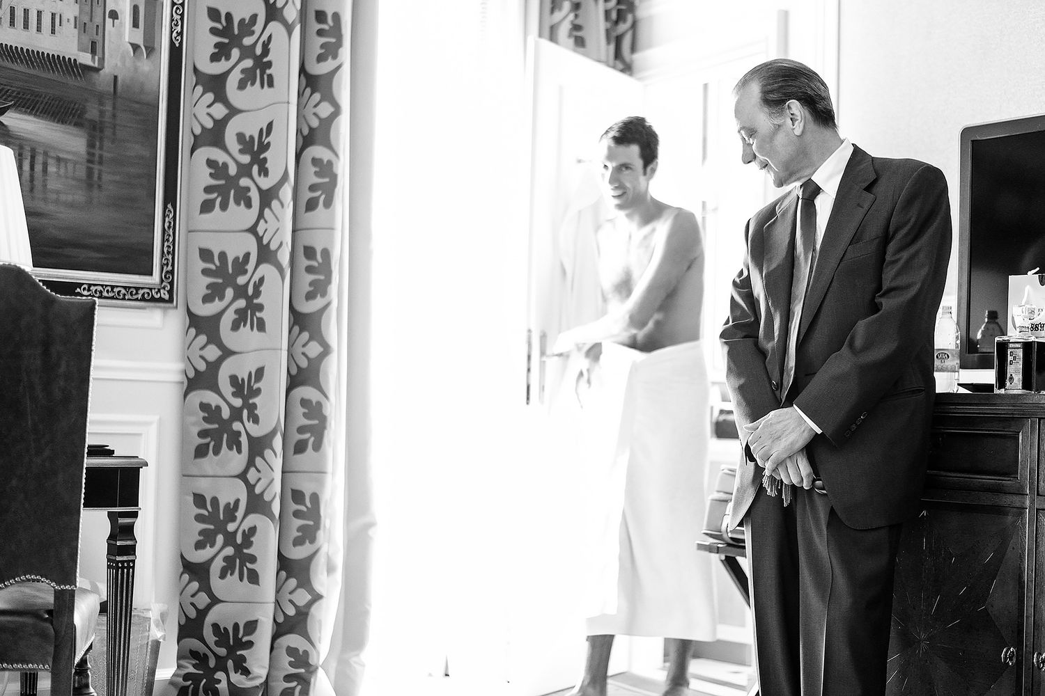 Black and white photos showing wedding preparation moments in a classic interior setting.