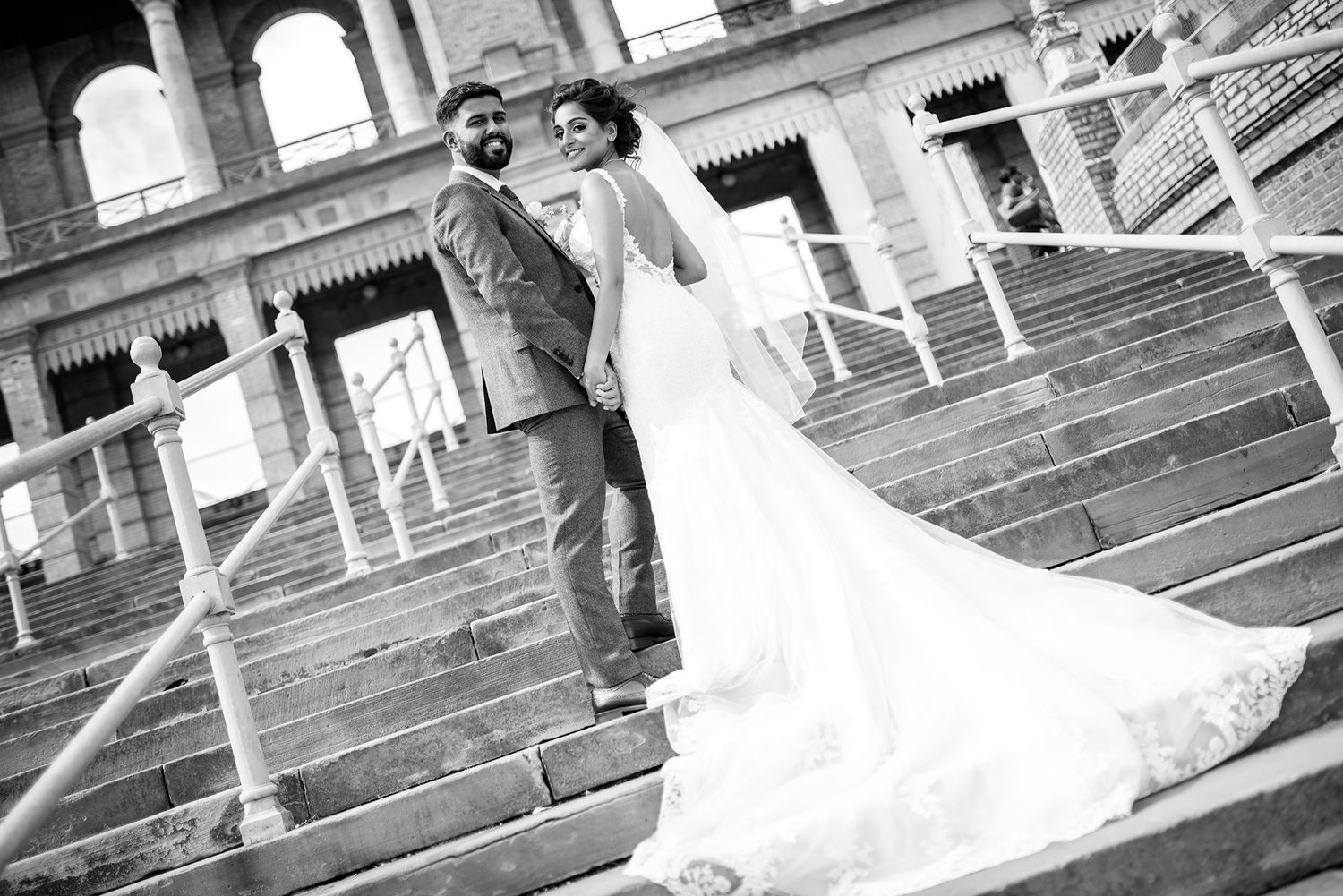 Dramatic wide-angle shots of wedding couple on stone steps with classic architecture.