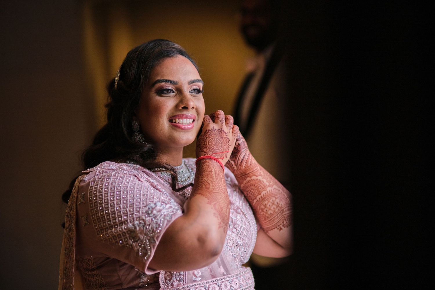 Traditional Indian bridal preparations showing hands adorned with henna and elegant jewelry.