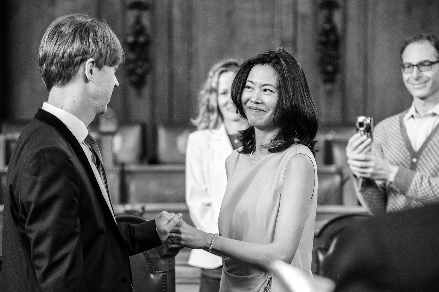 Wedding guests laughing and celebrating during an intimate indoor ceremony.