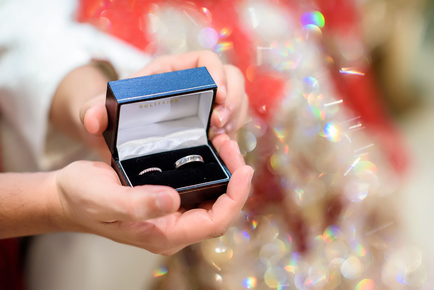 Close-up shots of engagement ring box with sparkly bokeh effects.