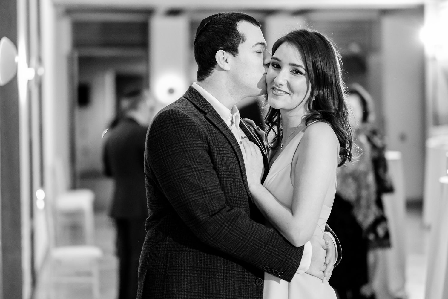 Candid black and white photo of couples sharing joyful moments at an event.