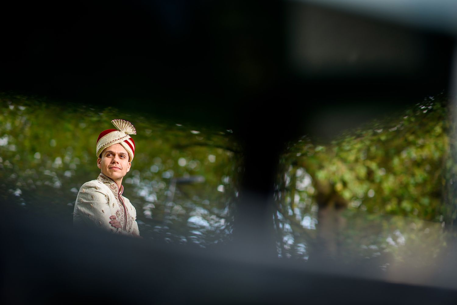 Artistic outdoor portrait through natural foliage and branches.