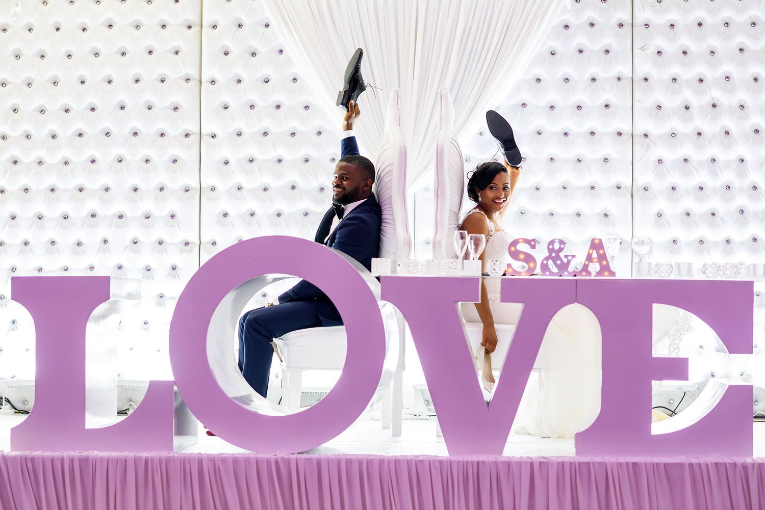 Modern wedding venue decorated with geometric patterns and purple lighting.