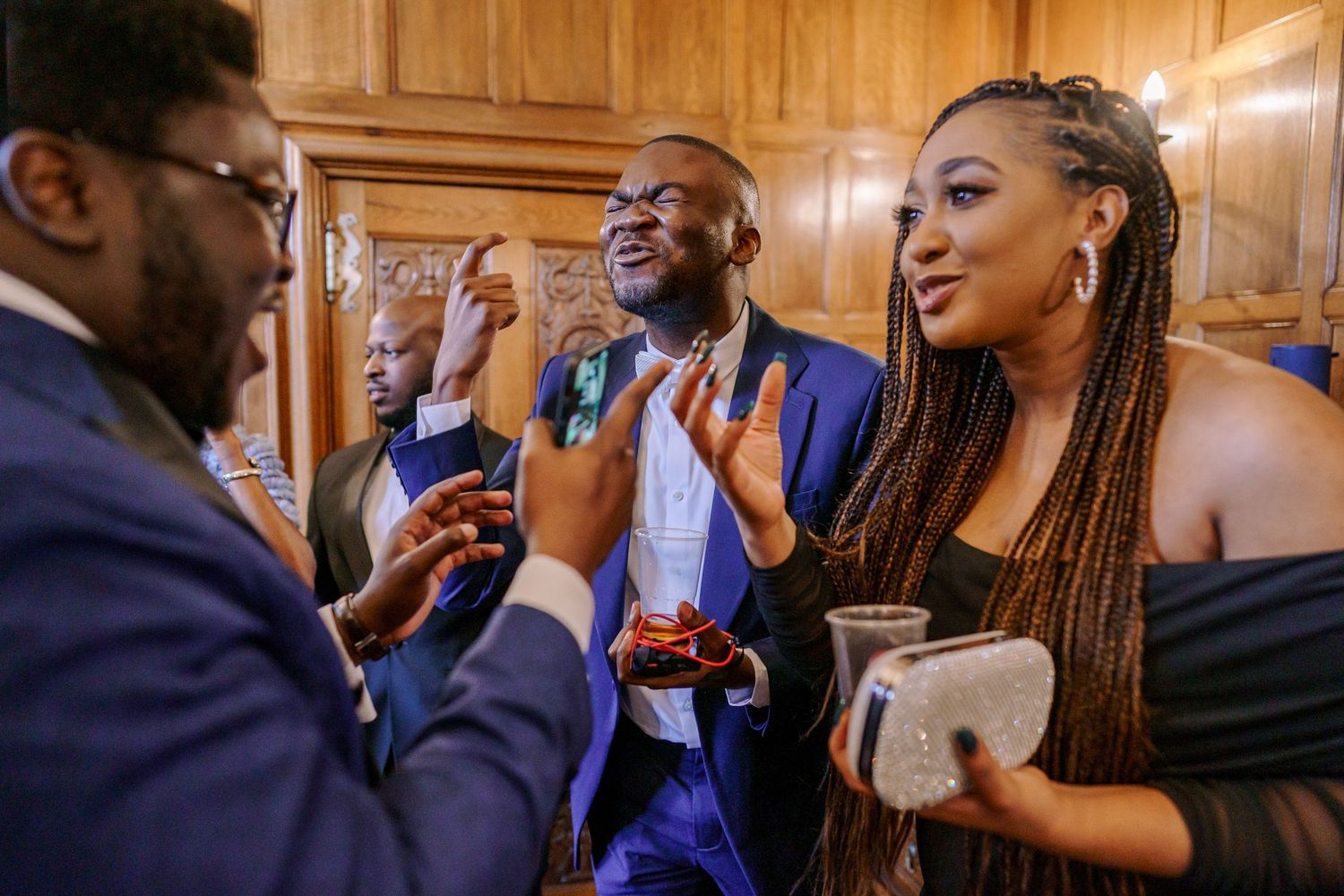 Wedding guests sharing laughter and conversation during an elegant indoor reception.