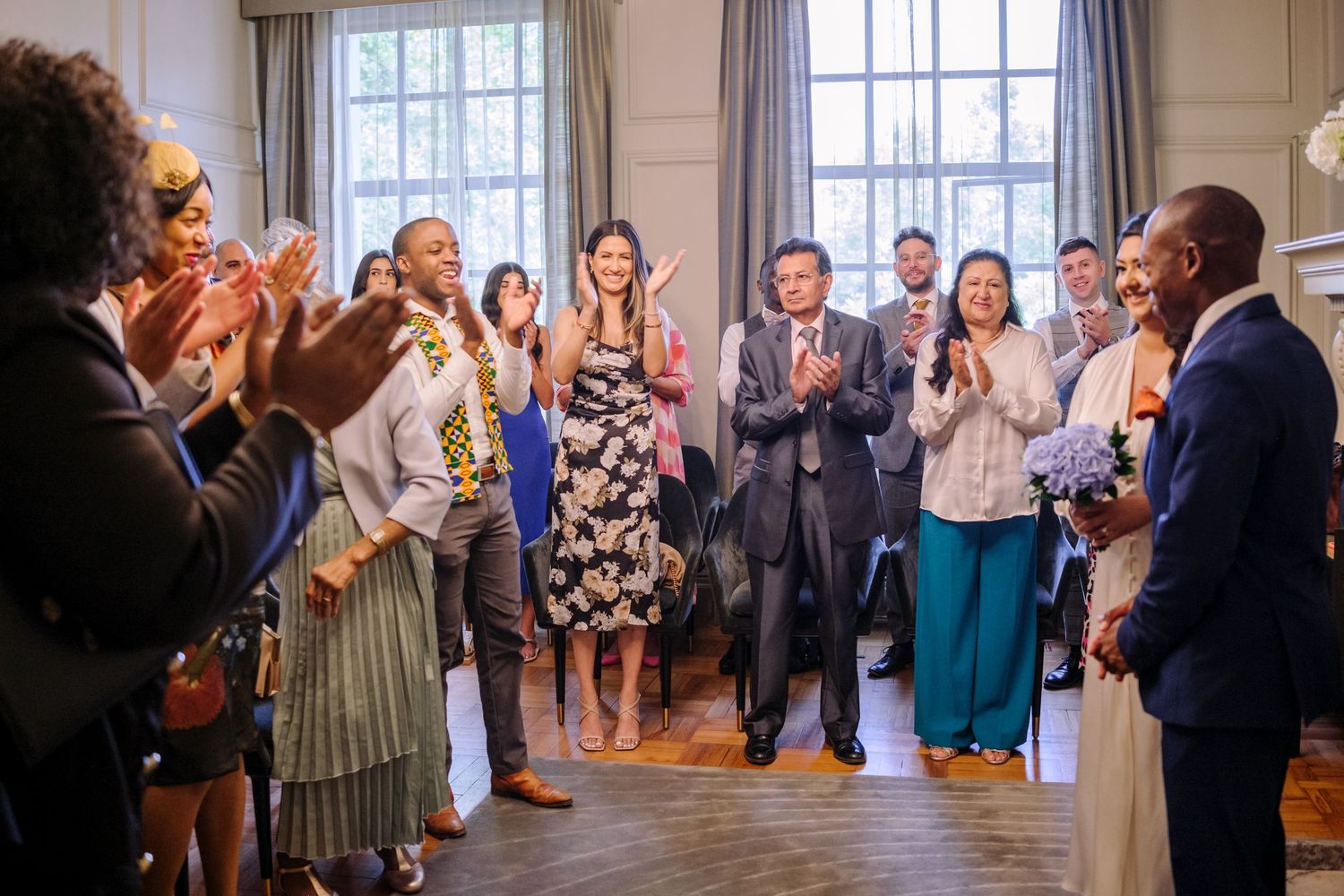 Wedding guests celebrate and dance together during a joyous reception in an elegant indoor venue.