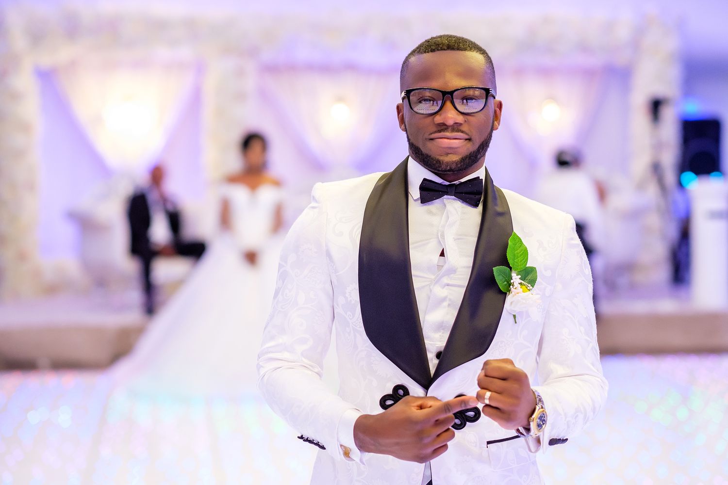 Wedding reception with elegant purple lighting and formal attire.
