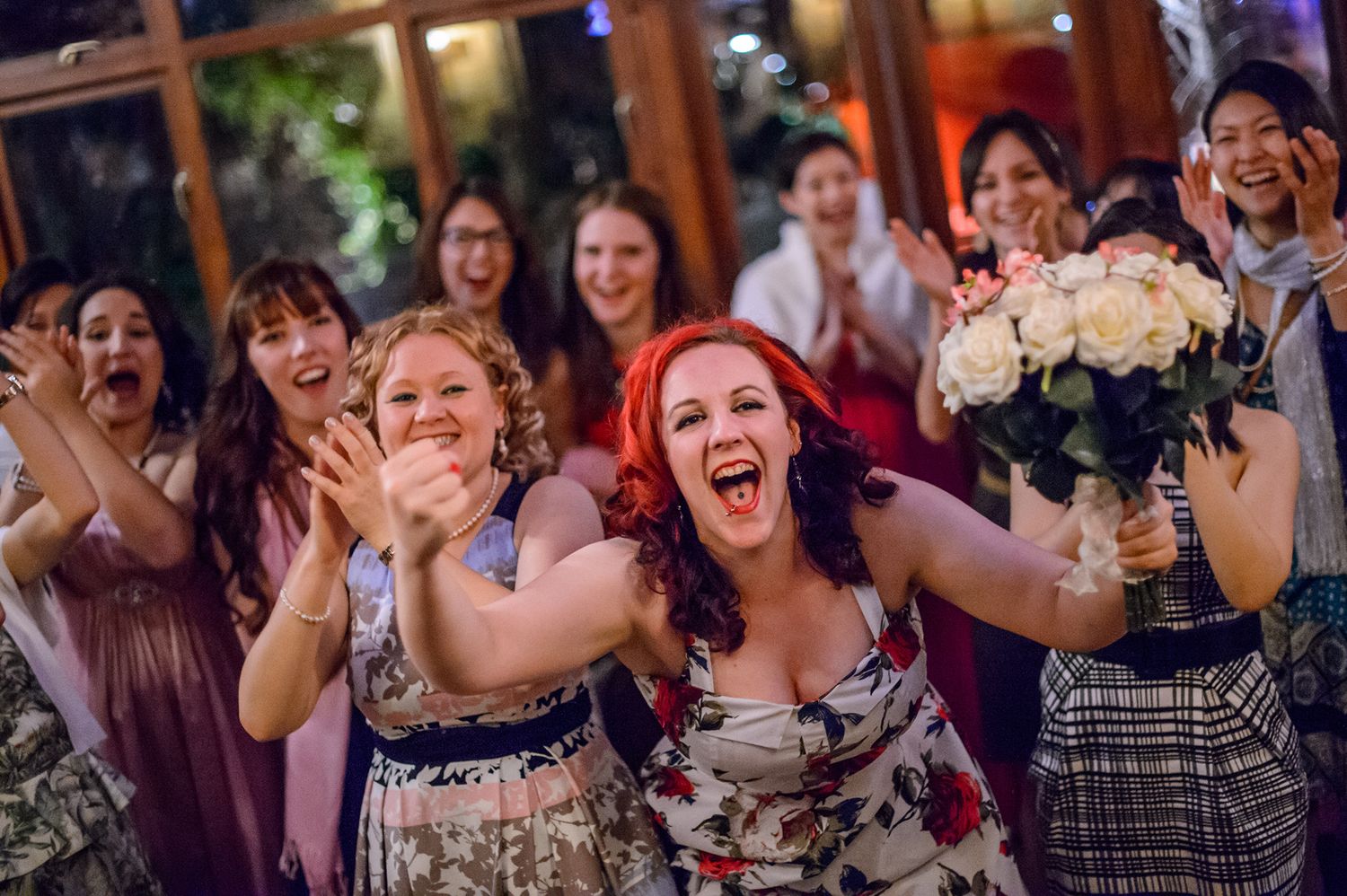 Wedding guests laugh and celebrate joyfully during reception party festivities.