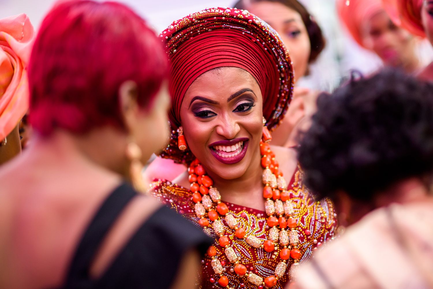 Guests in red attire celebrating energetically during a festive wedding reception.